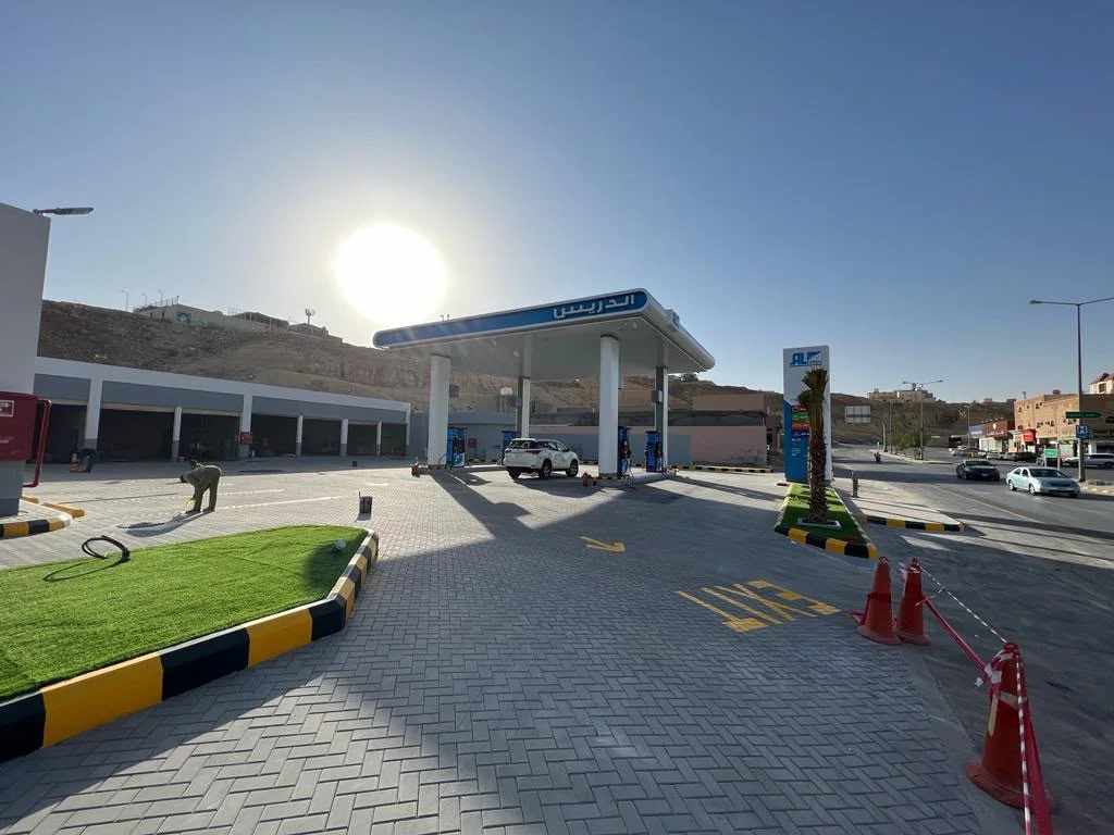 Finished paved forecourt with exit markings, landscaped island and roadside pylon